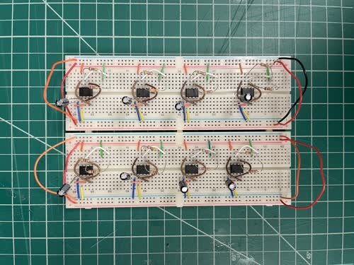 A breadboard containing eight 555 oscillator chips, each running at its own frequency